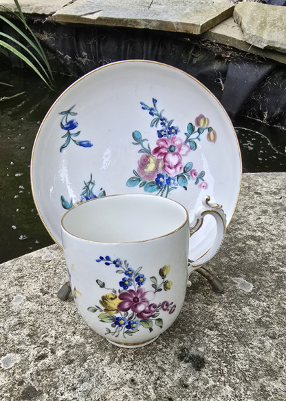 Tasse et sous tasse polychrome aux fleurs en porcelaine de Tournai.