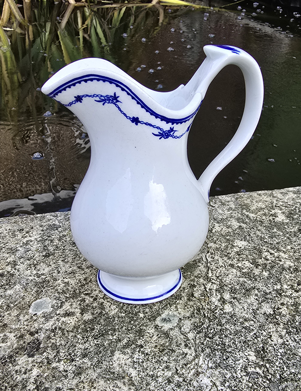 Pot à lait en forme de casque au décor Pensée couchée 19ème.