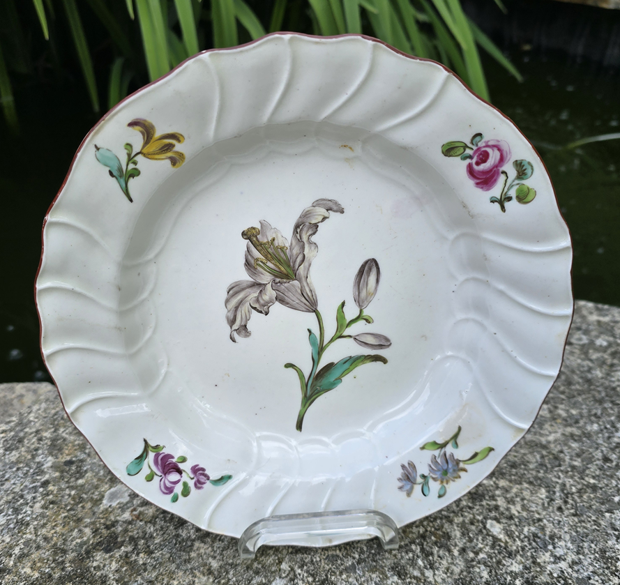 Assiette creuse en polychrome de Tournai décor d'un lys au centre.